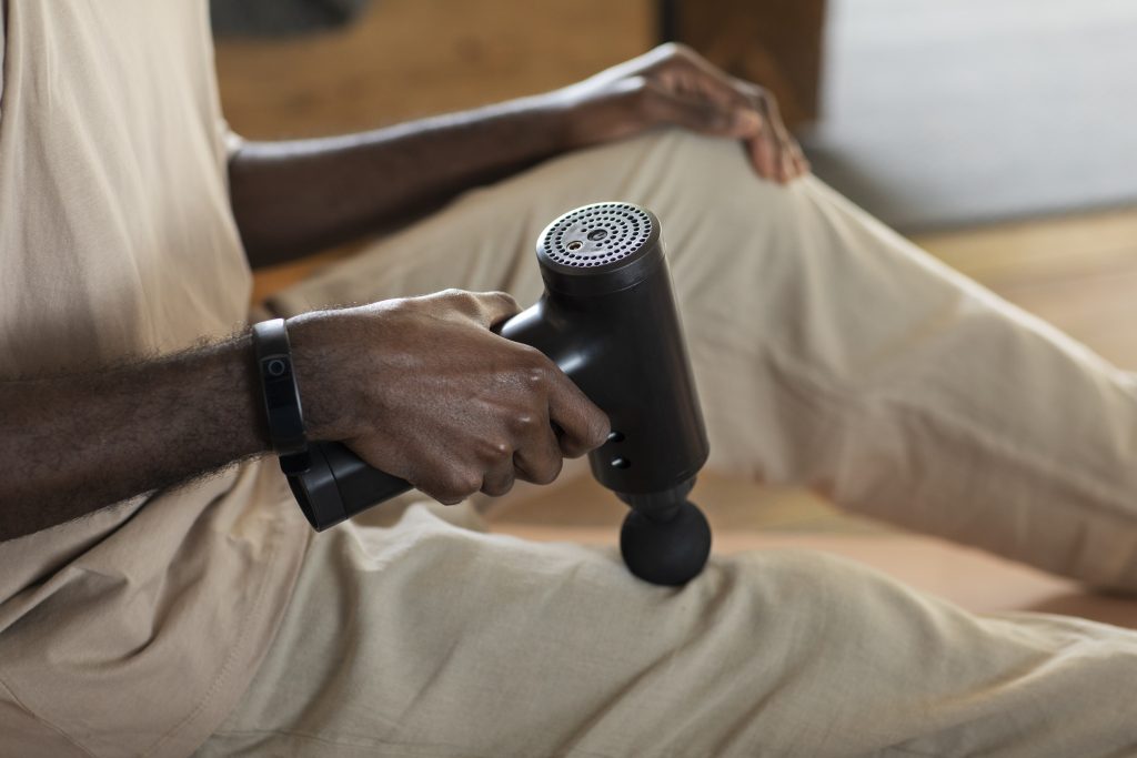 Personne utilisant son Theragun pour détendre ses muscles